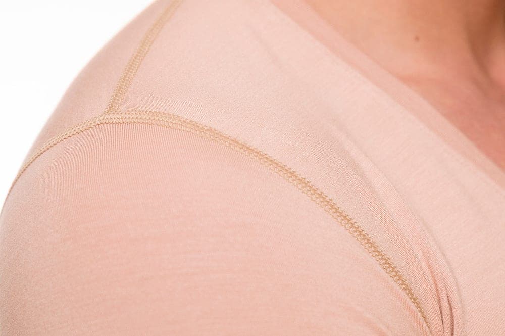 Close-up of the flat seam and thin hem at the shoulder of the undershirt